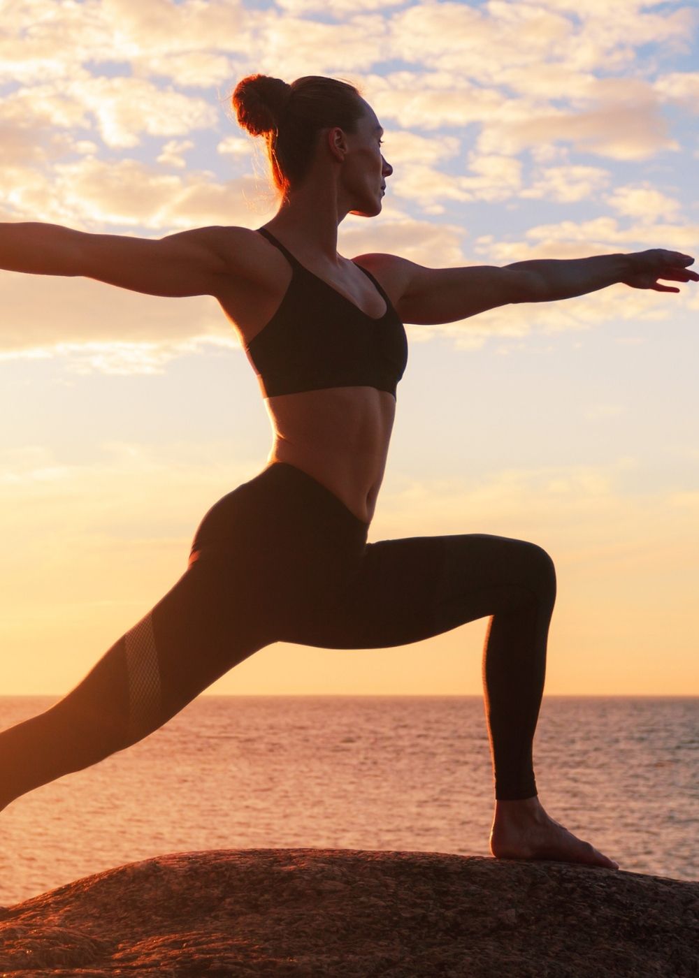 A woman doing yoga by the coast
